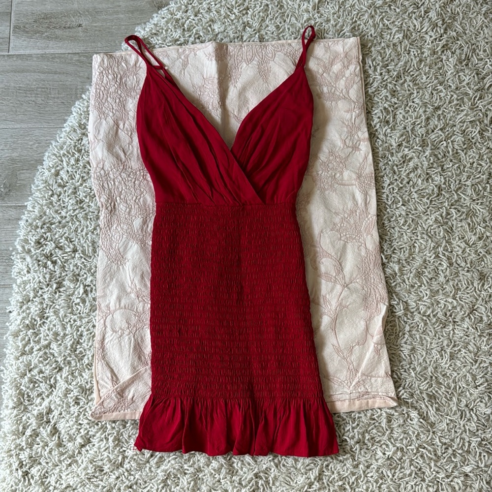 Red mini dress with ruffle bottom and deep V top. Adjustable straps